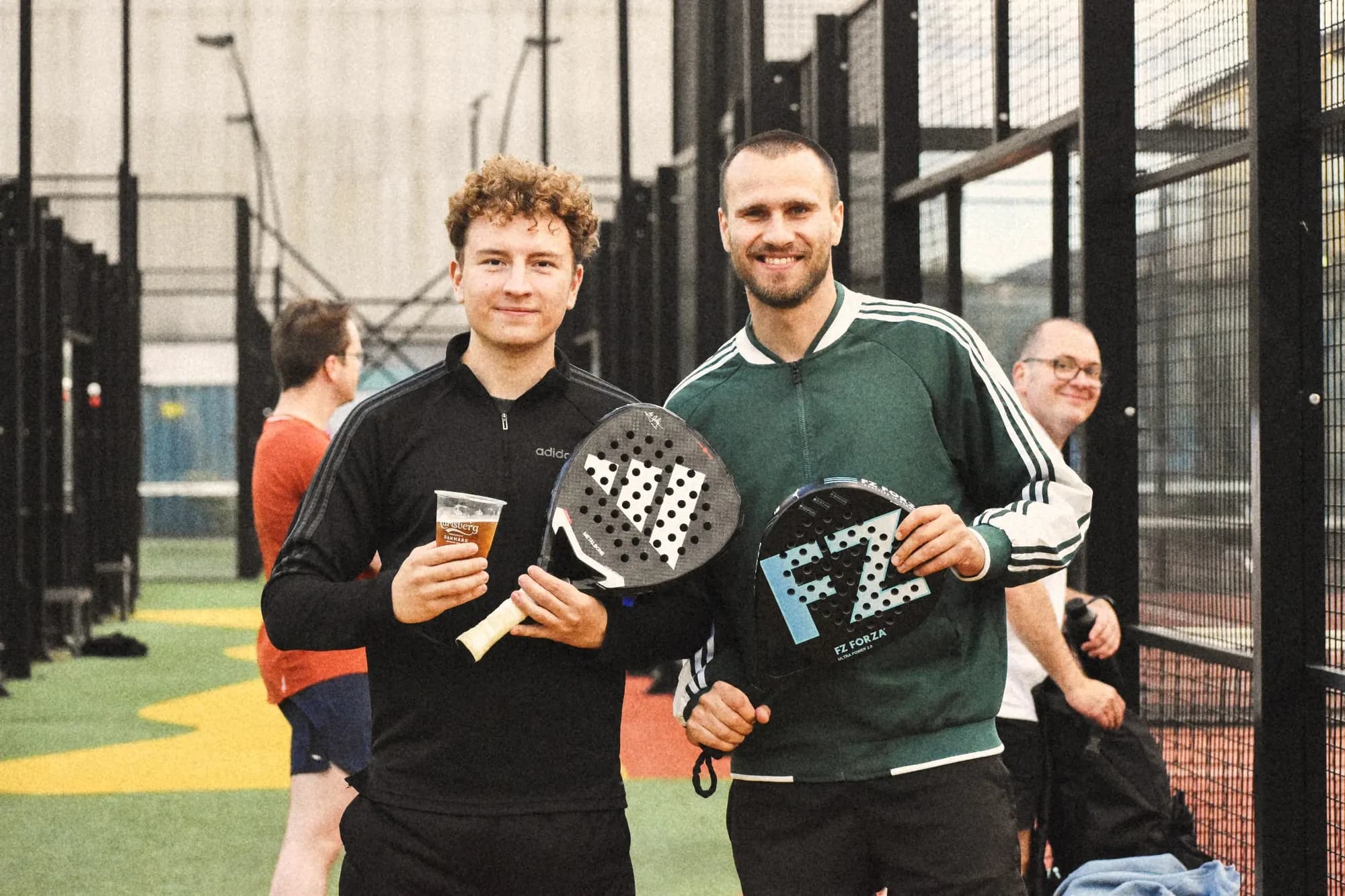 Venner, der griner mellem boldene til en athme-padelkamp