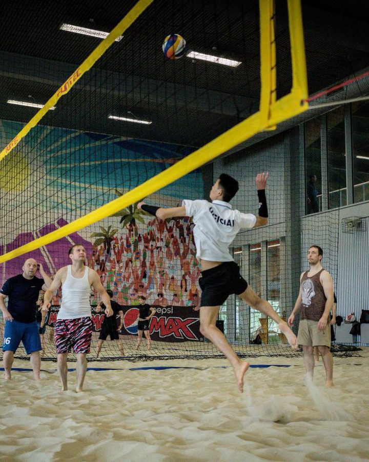 Players in the middle of a volleyball game organised through athme