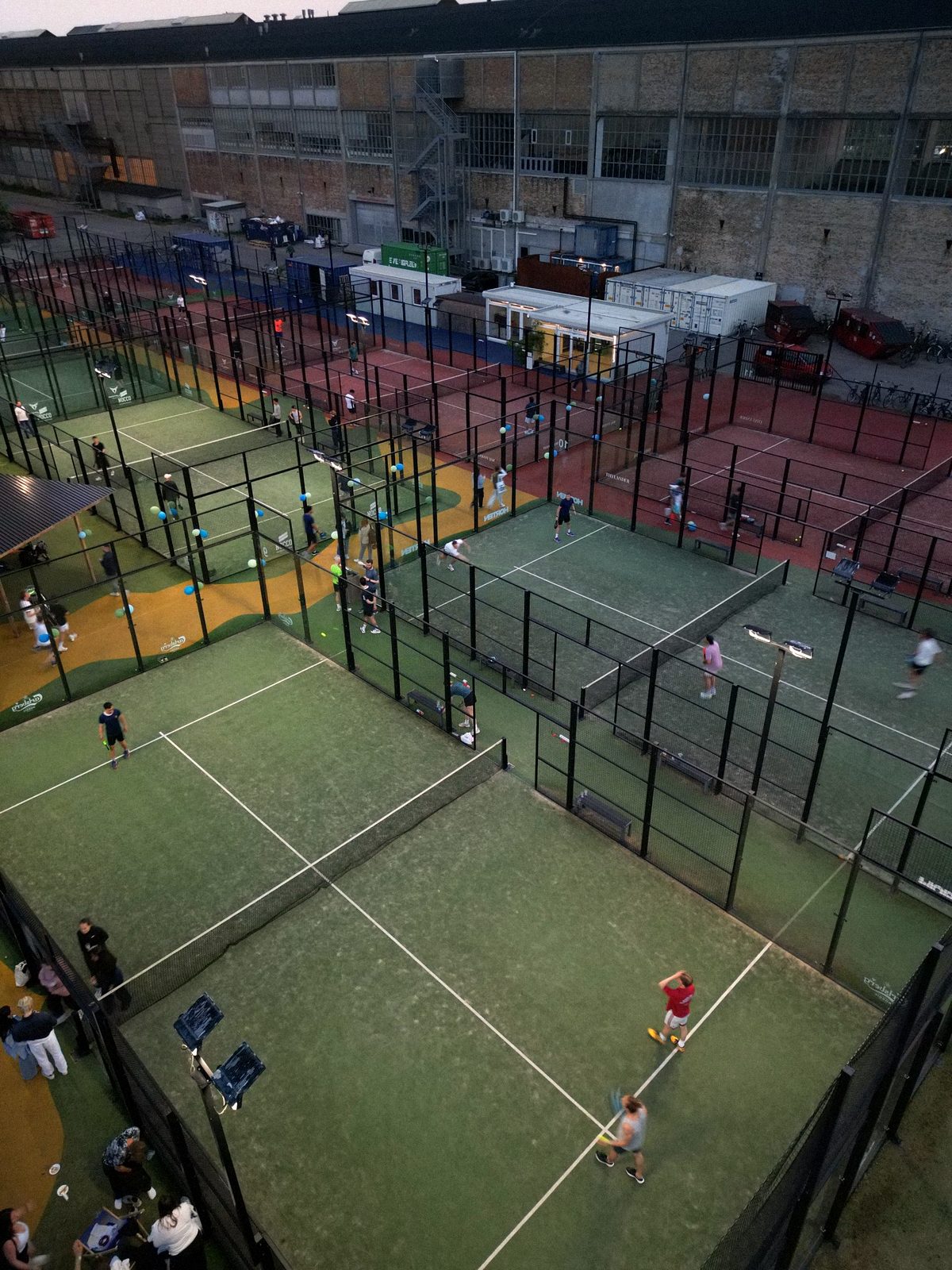 Aerial view of a busy athme padel night across many outdoor courts