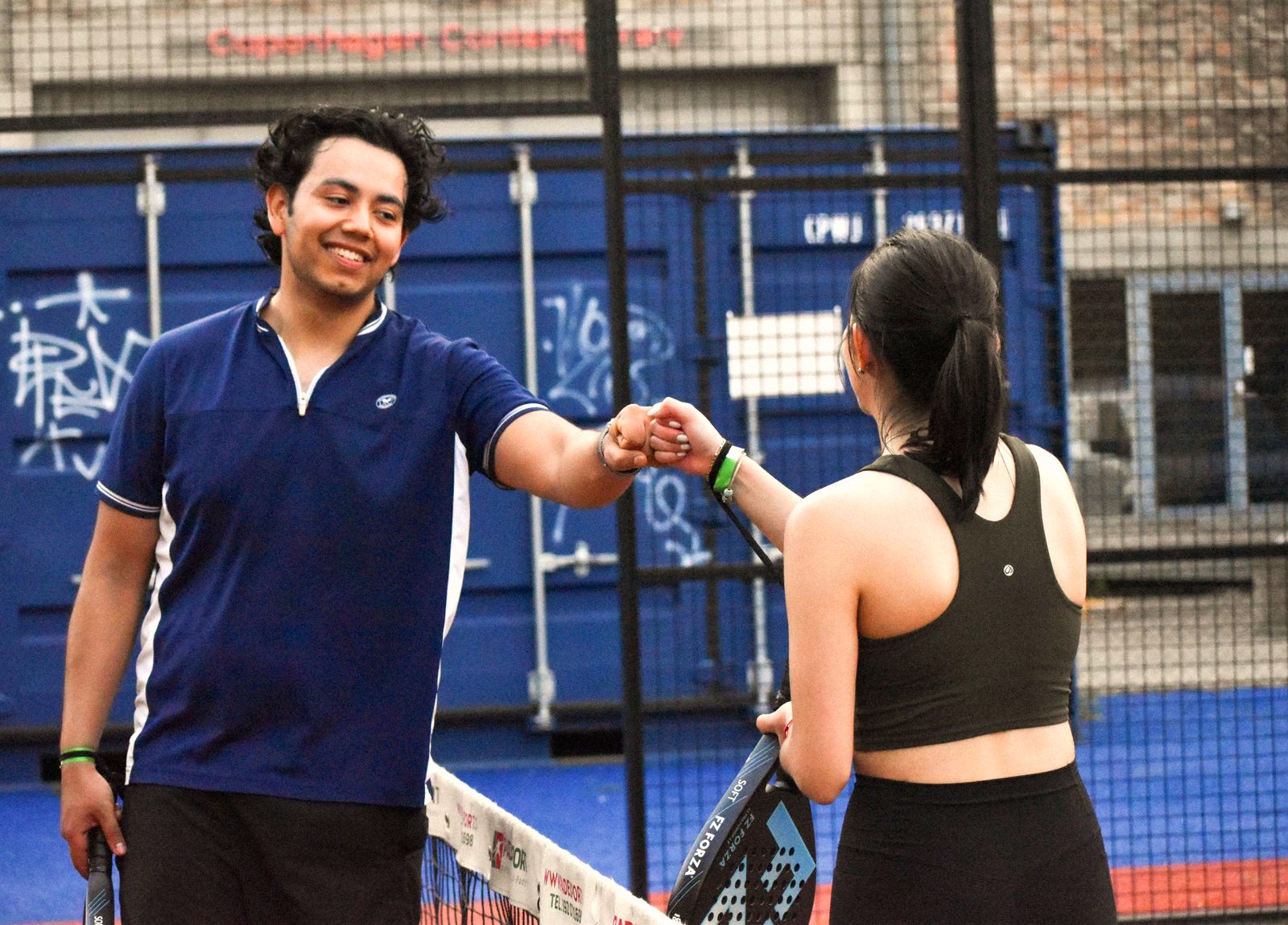 Two players bumping fists at the net