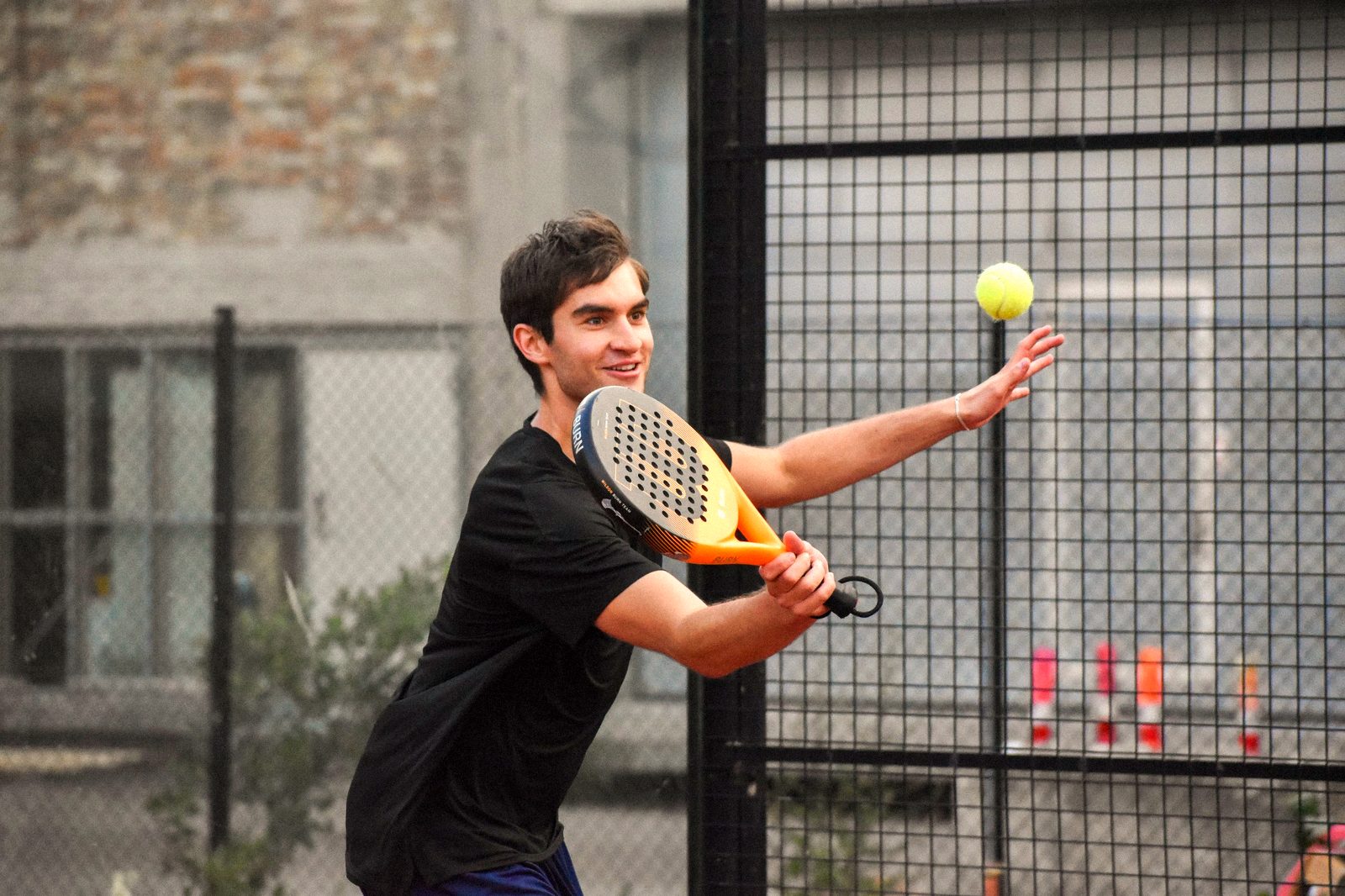 A player smiling as he hits a forehand