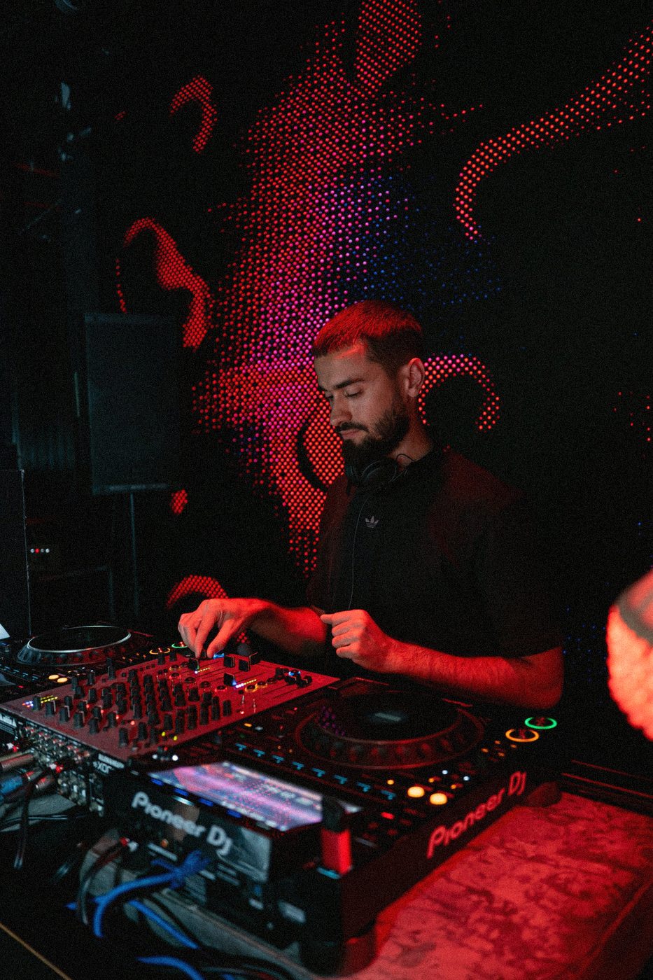 Techu mixing on Pioneer decks under red club lights